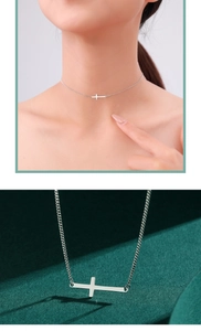 Detail of s925 sterling silver horizontal cross necklace on model and green background