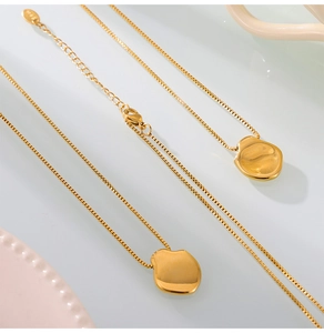 Close-up of golden irregular pebble pendant on a durable box chain with lobster clasp
