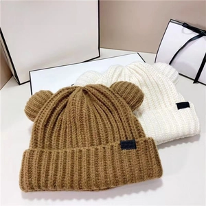 Détails de texture de bonnets en grosse maille avec oreilles d'ours en marron et crème