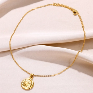 Détail du pendentif en relief soleil et lune sur collier plaqué or 18 carats