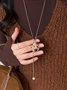 Detail of wooden horse pendant with diamond accents and pearl on silver snake chain