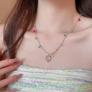 Dettaglio della collana con ciondolo a fragola in cristallo sulla modella