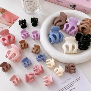 Flat lay of colorful matte hair clips in various sizes with stylish lifestyle props