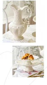 Detail of vintage French embossed white ceramic teapot and two-tier afternoon tea stand