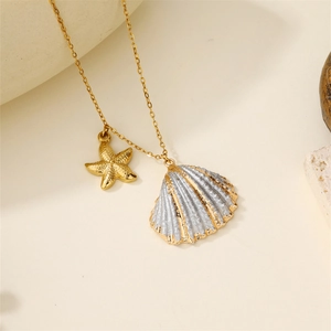 Detail view of gold starfish and bicolored seashell pendants on a fine link chain