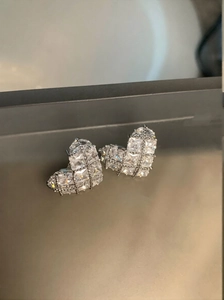 Macro shot of heart-shaped earrings with black plating and checkered cubic zirconia inlay