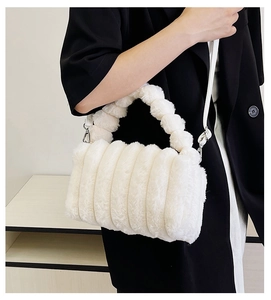 Detail of plush cream faux fur handbag featuring horizontal stripes and soft handles