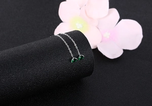 Macro view of S925 silver threader earrings with green teardrop zircon and long chain
