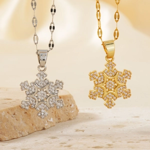 Vue détaillée des pendentifs flocon dorés et argentés avec sertissage en micro-zircon