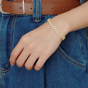 Primo piano di un bracciale a maglia cubana dorato con strass scintillanti sul modello
