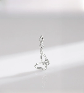 Close-up of a silver hollow butterfly pendant with a central sparkling zircon inlay