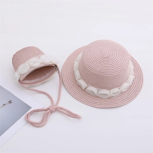 Close-up of pink straw hat and bag set with white roses and pearls for girls