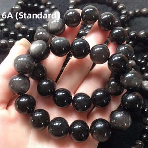 Close-up of 6A grade black obsidian beads showing natural silver sheen and texture