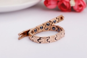 Nahaufnahme des roségoldenen Magnetarmbands mit eingebetteten schwarzen Germaniumsteinen