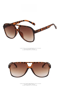 Detail of tortoise shell aviator sunglasses featuring double bridge and gradient tea lenses