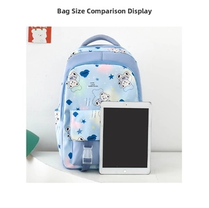 Detail view of colorful cartoon bear backpack showing size compared to a white tablet