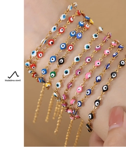 Detail of multi-colored evil eye charms on a gold-plated stainless steel chain bracelet