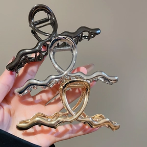Three-piece set of wave-shaped metallic hair claws in black, silver, and gold finishes