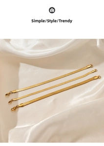 Three gold snake chain bracelets in different widths displayed on white silk background