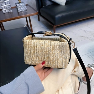 Women's straw crossbody bag with black leather trim and golden metal clasp closure