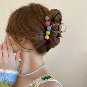 Detailed shot of transparent hair claw clip with colorful candy bead heart accents