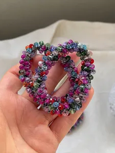 Detail of colorful faceted crystal beaded elastic hair ties in blue, red, and green