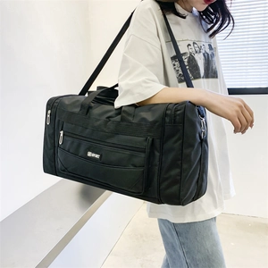 Detail of black nylon travel bag with SPORT logo and adjustable shoulder strap