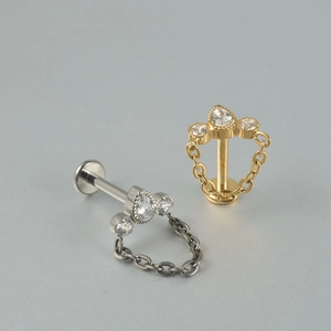 Titanium labret stud with zircon top and fine chain in silver and gold tones