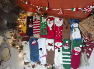 Flat lay of colorful Christmas coral fleece socks with festive embroidery and fluffy texture