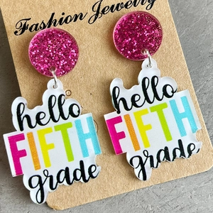 Detail view of Fifth Grade teacher earrings in pink glitter and acrylic on jewelry card