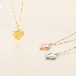 Minimalist heart pendant necklaces in gold, rose gold and silver on beige background