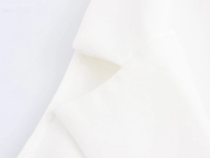 Detail shot of the elegant lapel and precise stitching on the white formal vest jacket