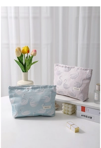 Detail of swan jacquard canvas makeup bags in pastel pink and blue with elegant embroidery