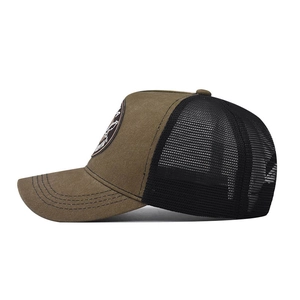 Close-up of brown and black trucker hat featuring vintage wild goose patch and mesh back