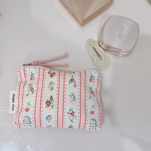 Detail of pink floral cotton pouch with side label showing zipper and soft fabric texture