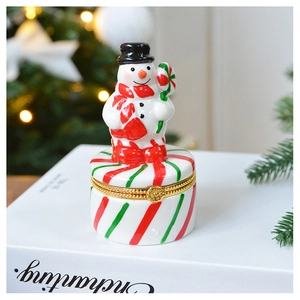 Detail of ceramic snowman jewelry box with metal clasp and red green striped base