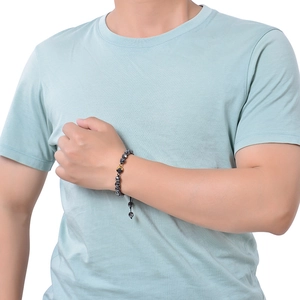 Detailed view of faceted tiger eye beaded bracelet with gold accent on male wrist