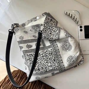 Detail view of ethnic paisley pattern cotton tote with leather strap and magnetic closure