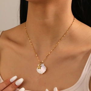 Detail of gold starfish and white shell pendants on a thin stainless steel chain for women