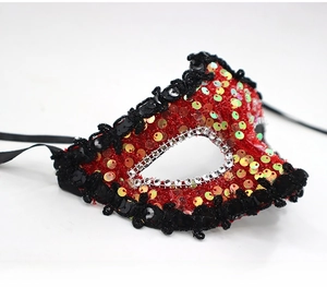 Detail of masquerade mask with red sequins, silver rhinestones, and black woven trim