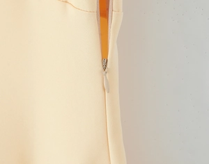 Vue macro d'une fermeture éclair invisible sur un tissu tissé élégant jaune clair