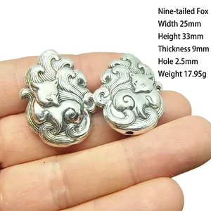 Macro shot of silver Nine-Tailed Fox pendant showing 25mm width and detailed carvings