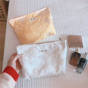 Floral relief fabric makeup bag with zipper closure and minimalist simple wish label