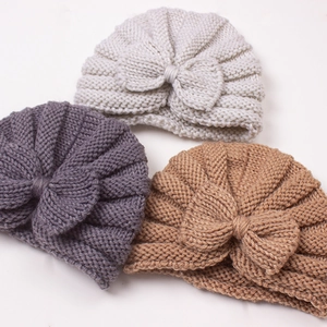 Three-piece set of knitted baby hats with large bows in beige, grey, and khaki colors