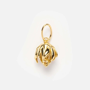 Detailed close-up of a gold-plated flower pendant featuring a yellow birthstone crystal