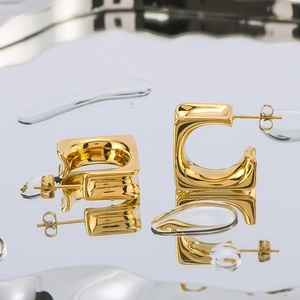 Elegant gold hollow square earrings on water ripple surface showing geometric minimalist style