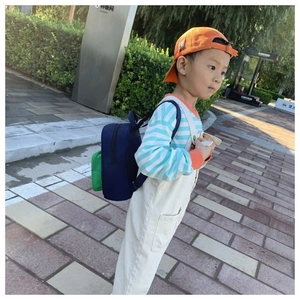 Side view of a blue and green color-block preschool backpack with adjustable straps