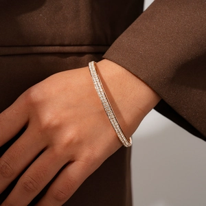 Detailed close-up of a gold double-row rhinestone geometric bangle worn on a wrist