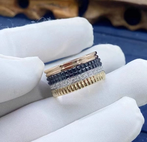 Close-up of multi-layer 18K gold and black ceramic ring with pavé diamond details