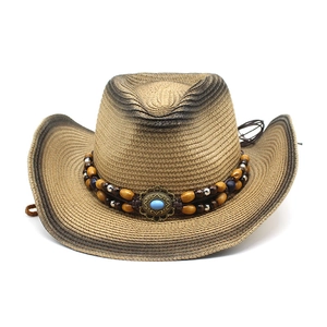 Detail of western straw cowboy hat featuring beaded band and turquoise stone accent